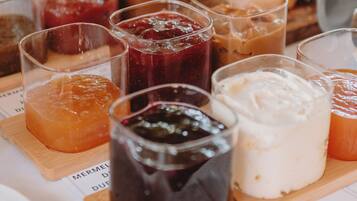 Una mesa con diversas opciones de comida, como frutas, pasteles y salsas.