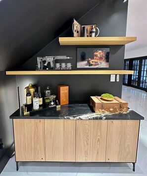Eine moderne Küche mit einem Holzkorpus, einer schwarzen Arbeitsplatte und verschiedenen Küchenutensilien.