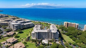 A resort with multiple buildings, a pool area, and a view of the ocean.