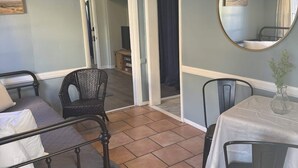 A room with a bed, a dining table with chairs, a mirror, and a hanging light fixture. - Unit 17 King suite kitchen Fast Wifi Smart TV (Hot Springs)