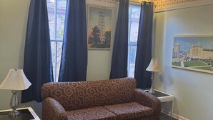 A living room with a patterned sofa, two lamps, a rug, and two framed pictures on the wall. - Unit 17 King suite kitchen Fast Wifi Smart TV (Hot Springs)