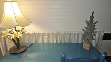 Une table bleue avec une lampe et une plante en pot.