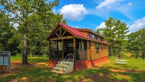 Een chalet met veranda, trappen en uitzicht op het omliggende bos.