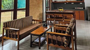 A spacious living room with a high ceiling, large windows, and a kitchen area. - Seagulls Garden -450 m to beach & Free* Utility (Hikkaduwa)