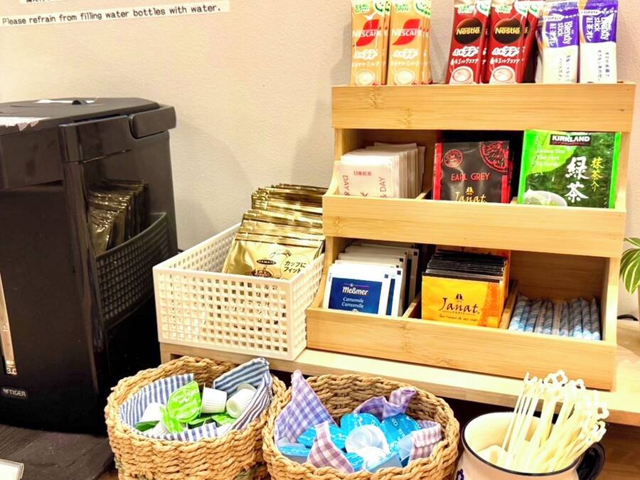 A room with a trash bin, a shelf with various packaged goods, and two baskets with items.