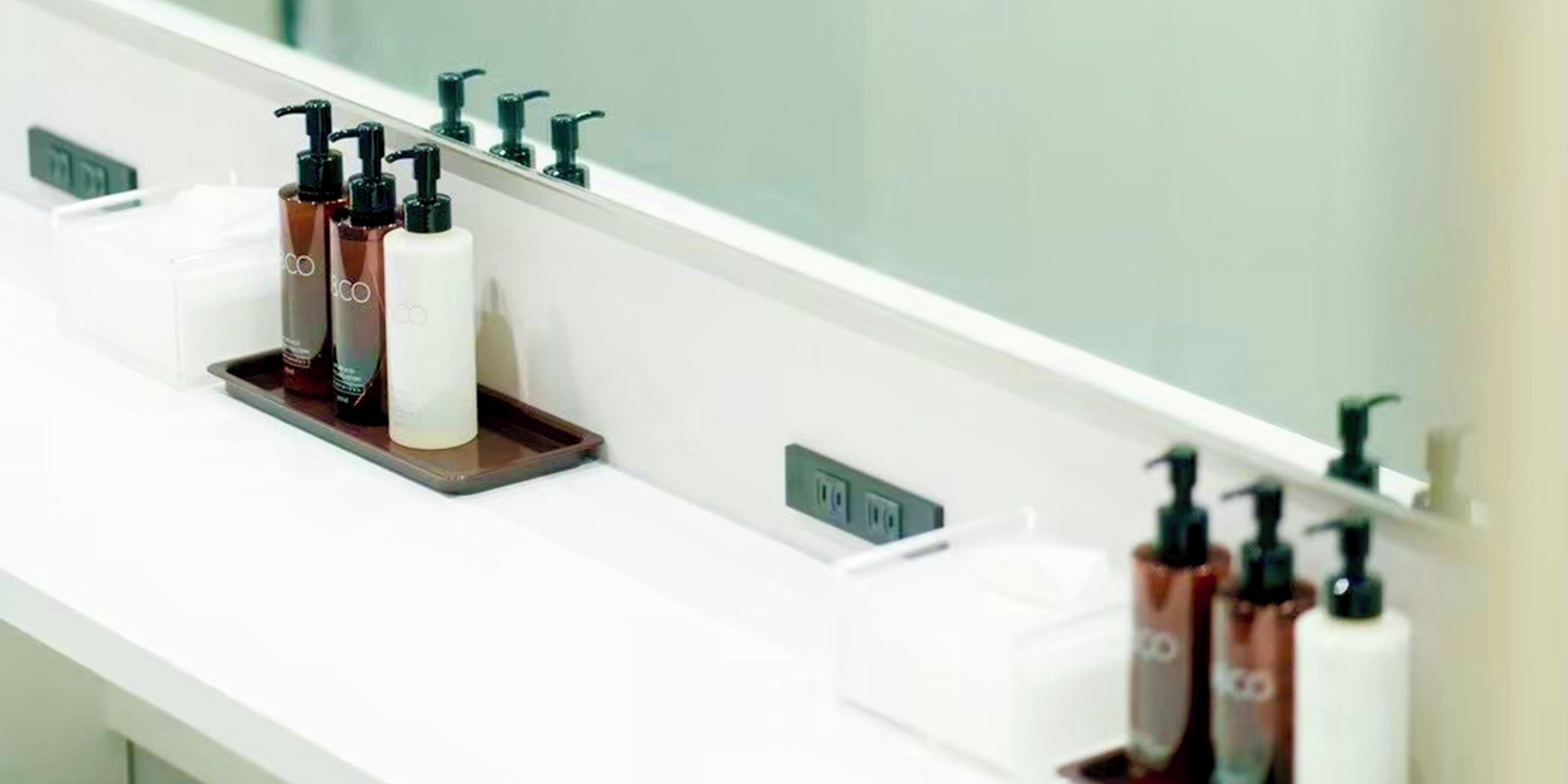 Un meuble-lavabo dans une salle de bain, avec des articles de toilette et un miroir.