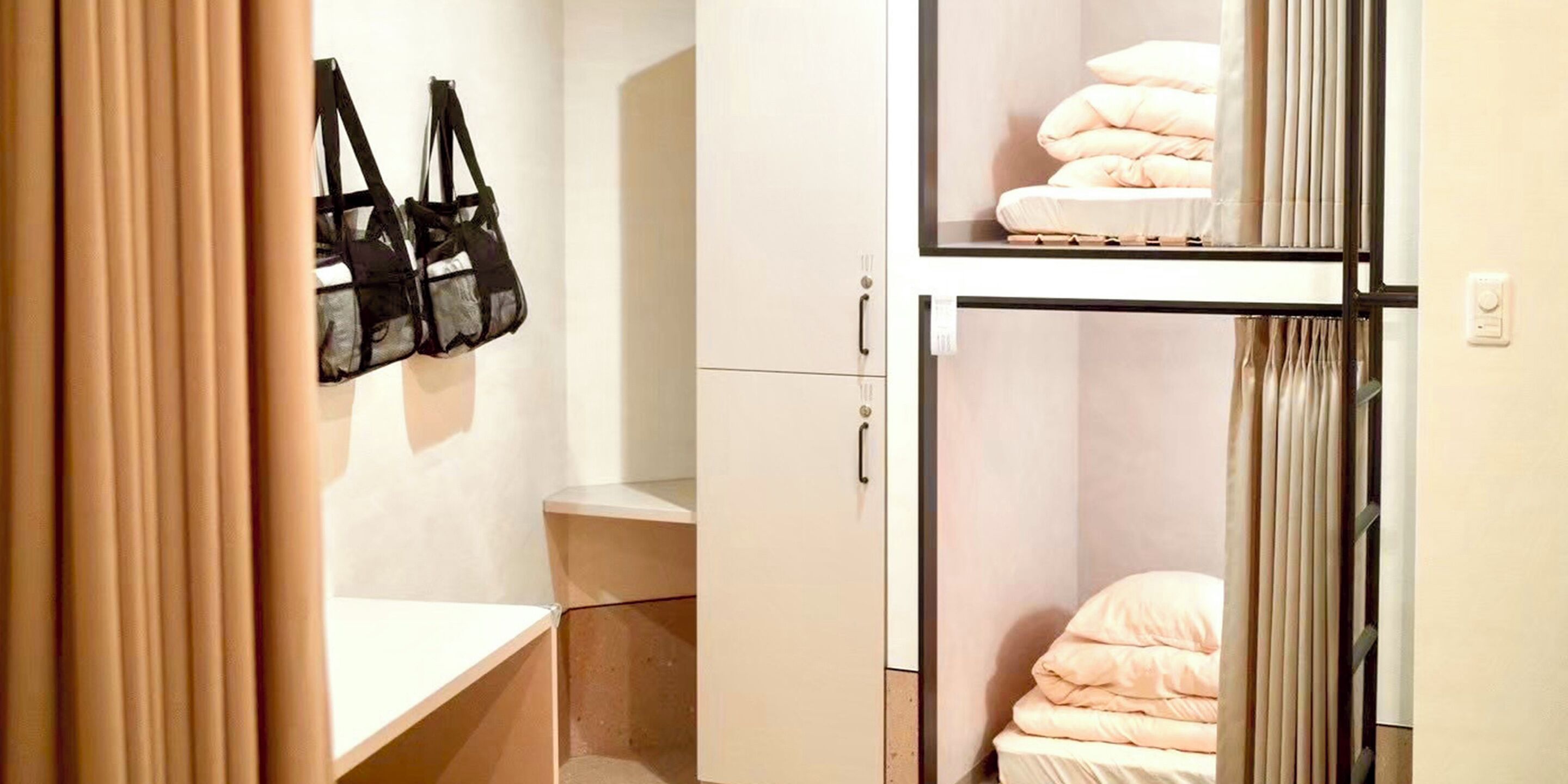 Ein kleines Zimmer mit Bett, Tisch und Kleiderschrank.