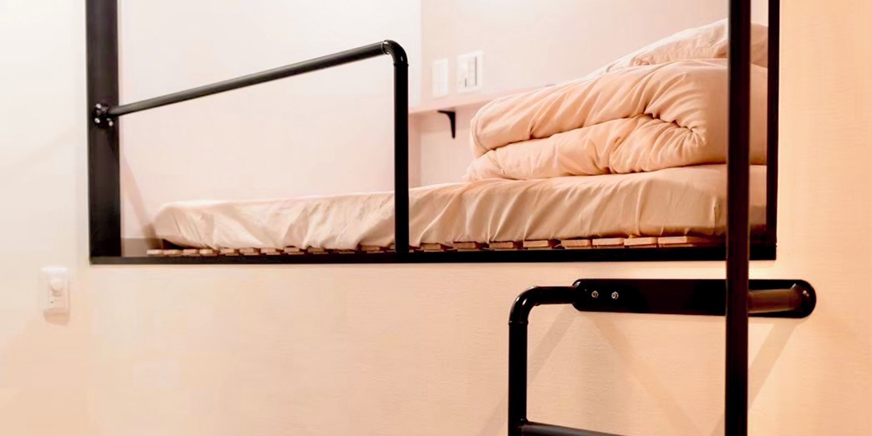 A bunk bed with a black metal frame and a mirror above it.