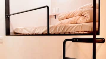 A bunk bed with a black metal frame and a mirror above it.