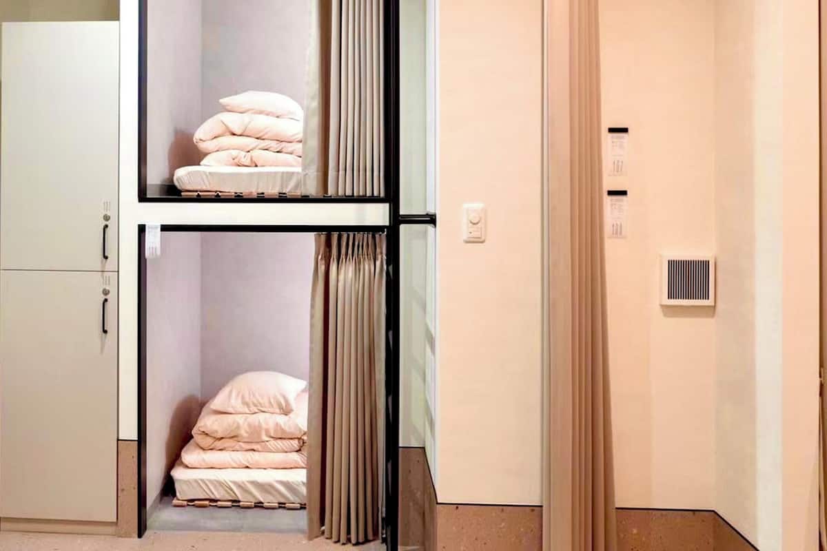 A room with a bed, a wardrobe, and a small table.