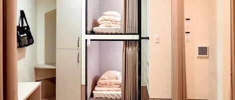 A room with a bed, a wardrobe, and a small table.
