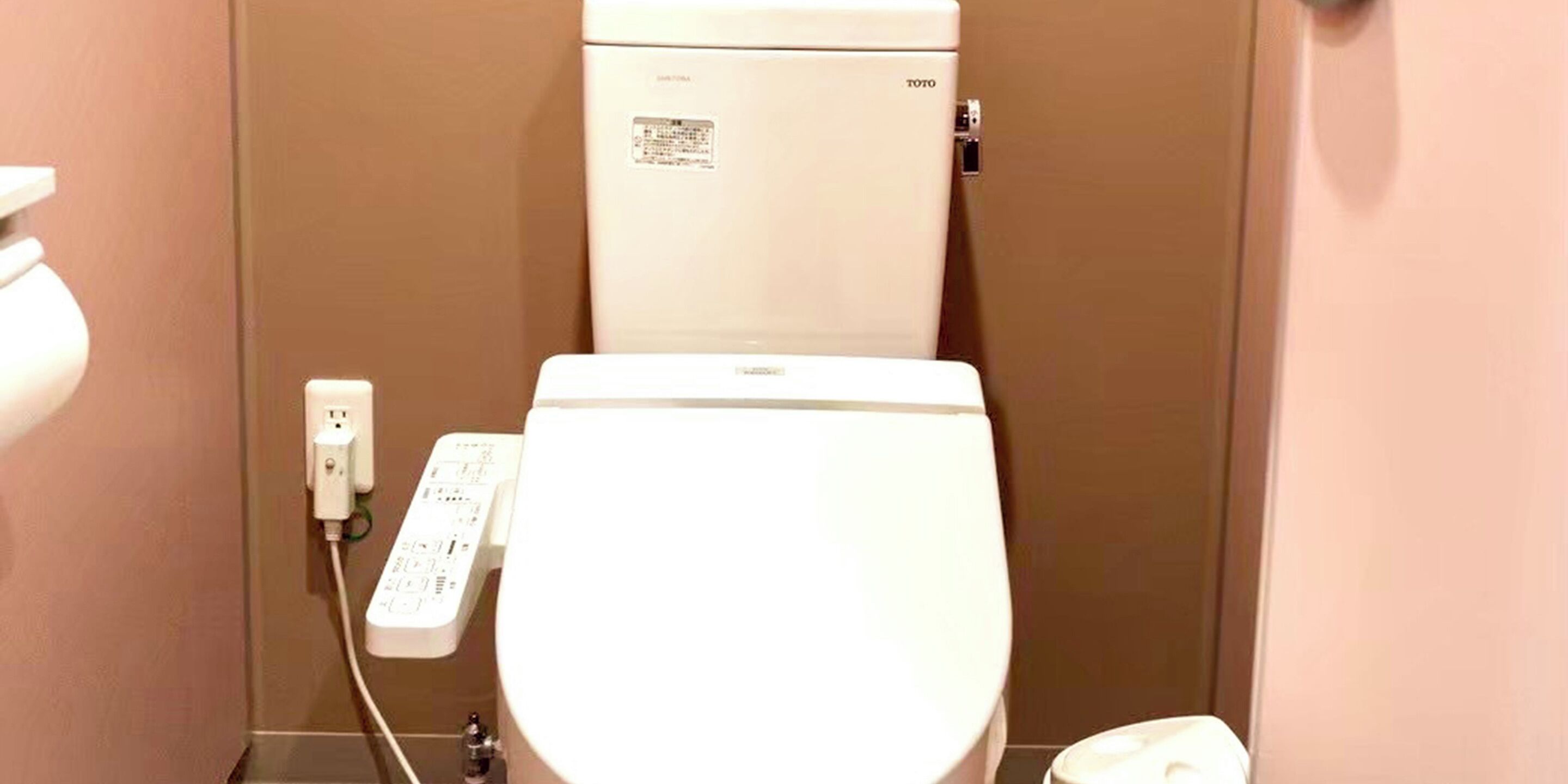 A white toilet with a control panel and a TOTO brand label.