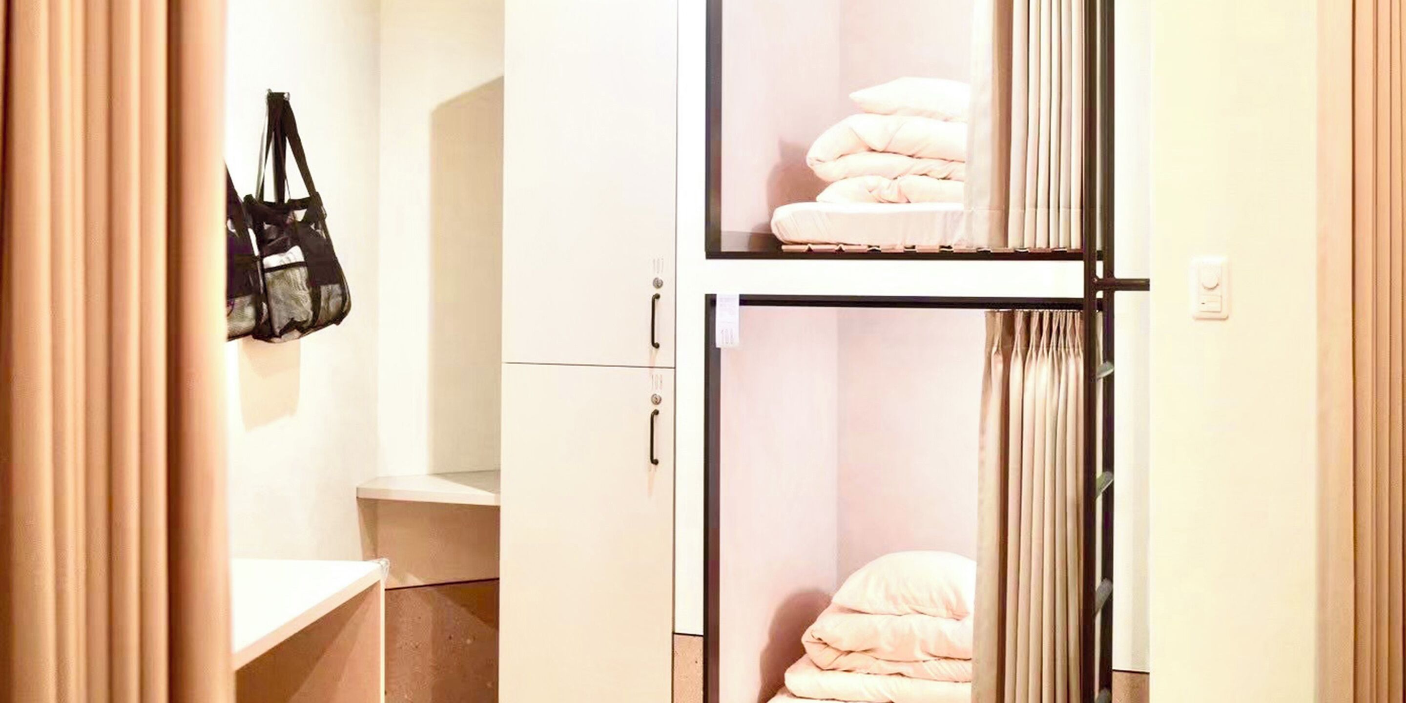 A hotel room with a bed, a wardrobe, and a small table.