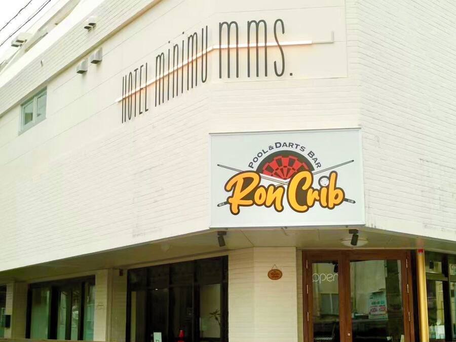 A building with a sign for "HOTEL MINIMU MMs" and a "POOL & DARTS BAR Ron Crib."