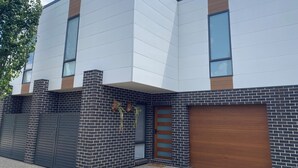 A modern building with a flat roof, large windows, and a brick facade.