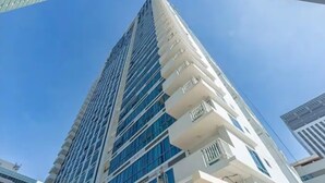 A tall, modern building with a glass facade and white balconies. - Luxurious 2-BR, 2-BA, 34th Flr, 38 Park Avenue (Cebu City)