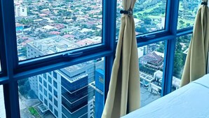 A room with a large window offering a cityscape view. - Luxurious 2-BR, 2-BA, 34th Flr, 38 Park Avenue (Cebu City)