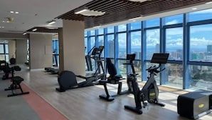 A modern gym with cardio machines, weight benches, and a red carpet. - Luxurious 2-BR, 2-BA, 34th Flr, 38 Park Avenue (Cebu City)
