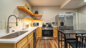 A modern kitchen with stainless steel appliances, wooden cabinets, and a built-in oven. - The E-town Hideaway (Elizabethtown)