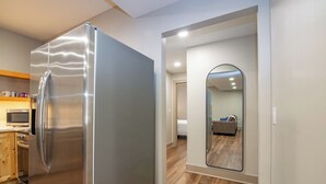 A modern kitchen with a stainless steel refrigerator, wooden cabinets, and a microwave. - The E-town Hideaway (Elizabethtown)