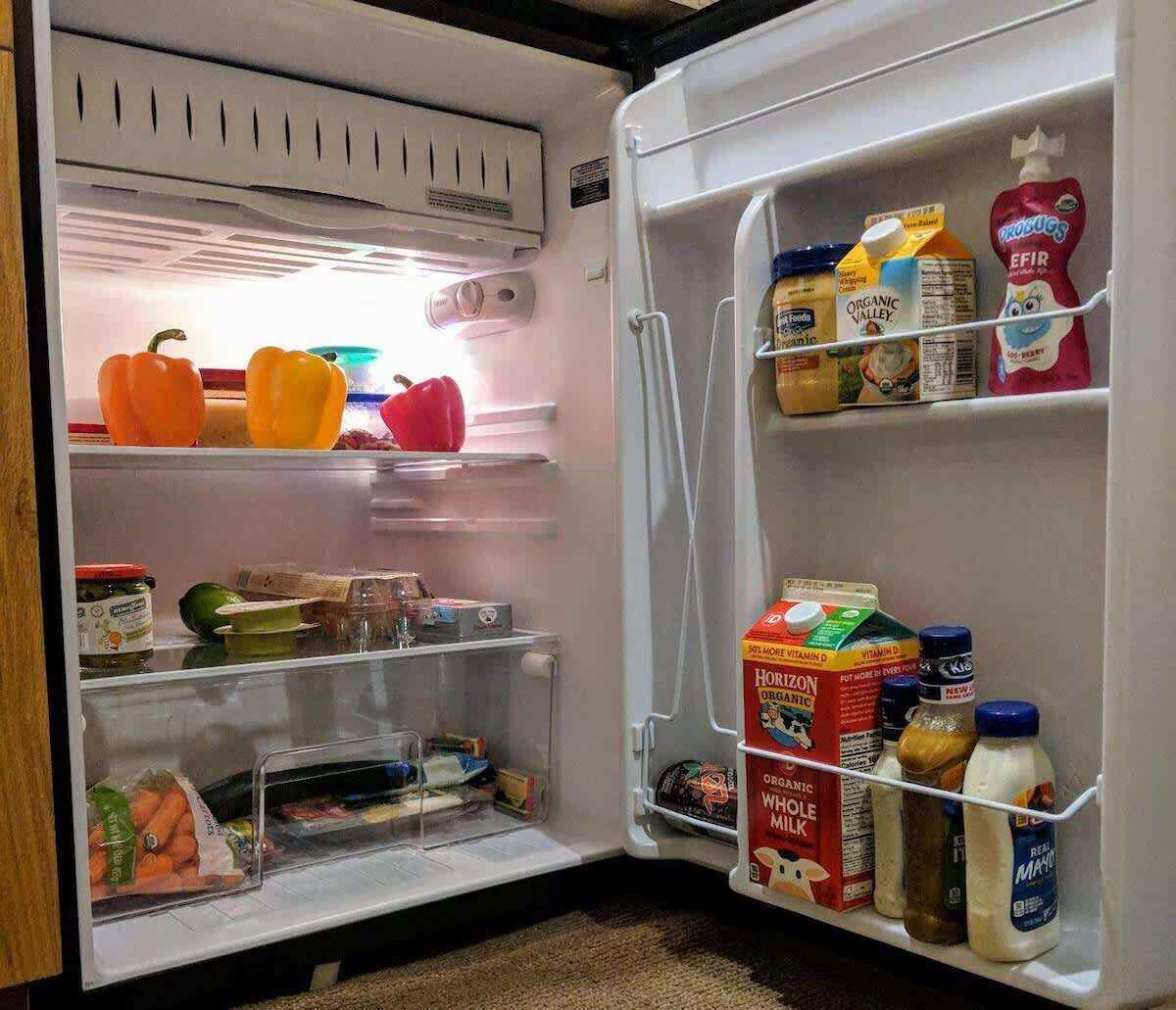 An open refrigerator with various food items and beverages.