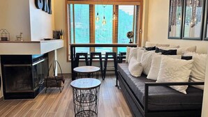 A modern living room with a sofa, two round tables, and a fireplace. - Mountain view Durango ski-in/out@ Purgatory Resort (Durango)