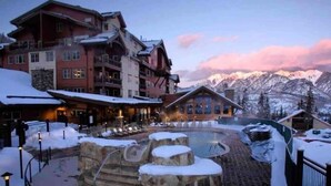 A hotel with a pool area, snow-covered landscape, and mountains in the background. - Mountain view Durango ski-in/out@ Purgatory Resort (Durango)