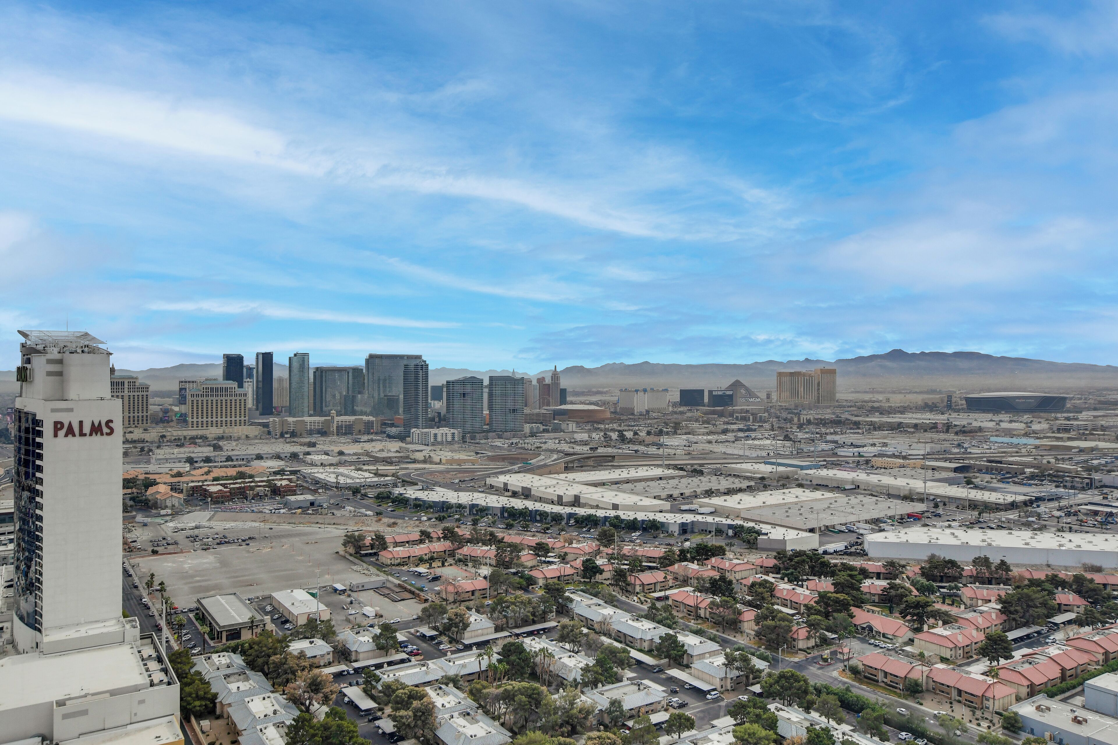 A cityscape with a prominent 'PALMS' building, various high-rise buildings, and a mix of residential and commercial areas.