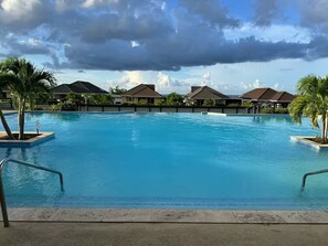 Una piscina con vista su edifici in stile resort e palme.