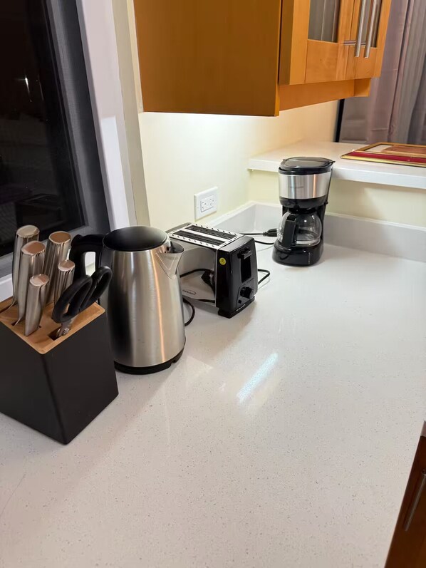 A kitchen with a toaster, coffee maker, and a kettle on a white countertop. - Hillcrest Heaven Elegant Escape in Richmond Estate, St. Ann with Private Beach (Priory)