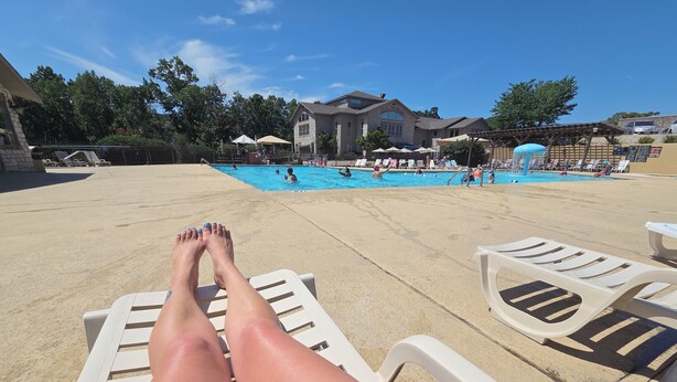 Un espace aménagé au bord de la piscine, avec des chaises longues et une piscine.