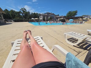 A poolside area with lounge chairs and a swimming pool. - Cozy 1-bedroom condo in enchanting Branson with WiFi, fitness room and pools (Branson)