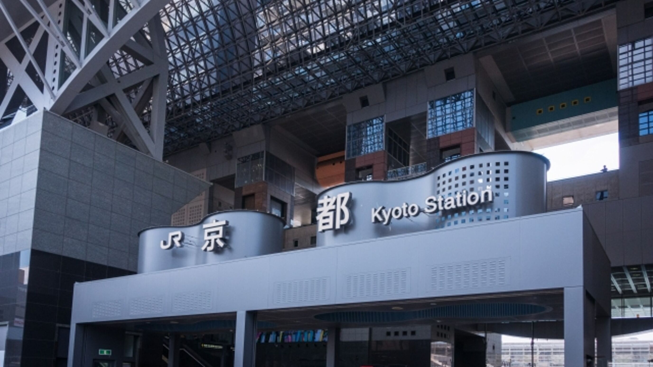 A modern building with a sign that reads "Kyoto Station".