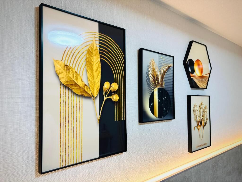 Un mur orné de trois œuvres d’art encadrées représentant des feuilles et des fleurs.