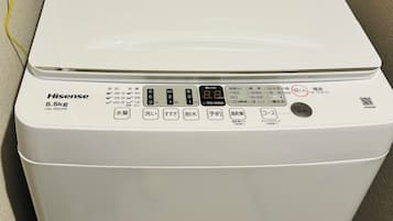 Una lavadora Hisense de 5.5 kg con carga frontal, pantalla digital, panel de control y cable de alimentación.
