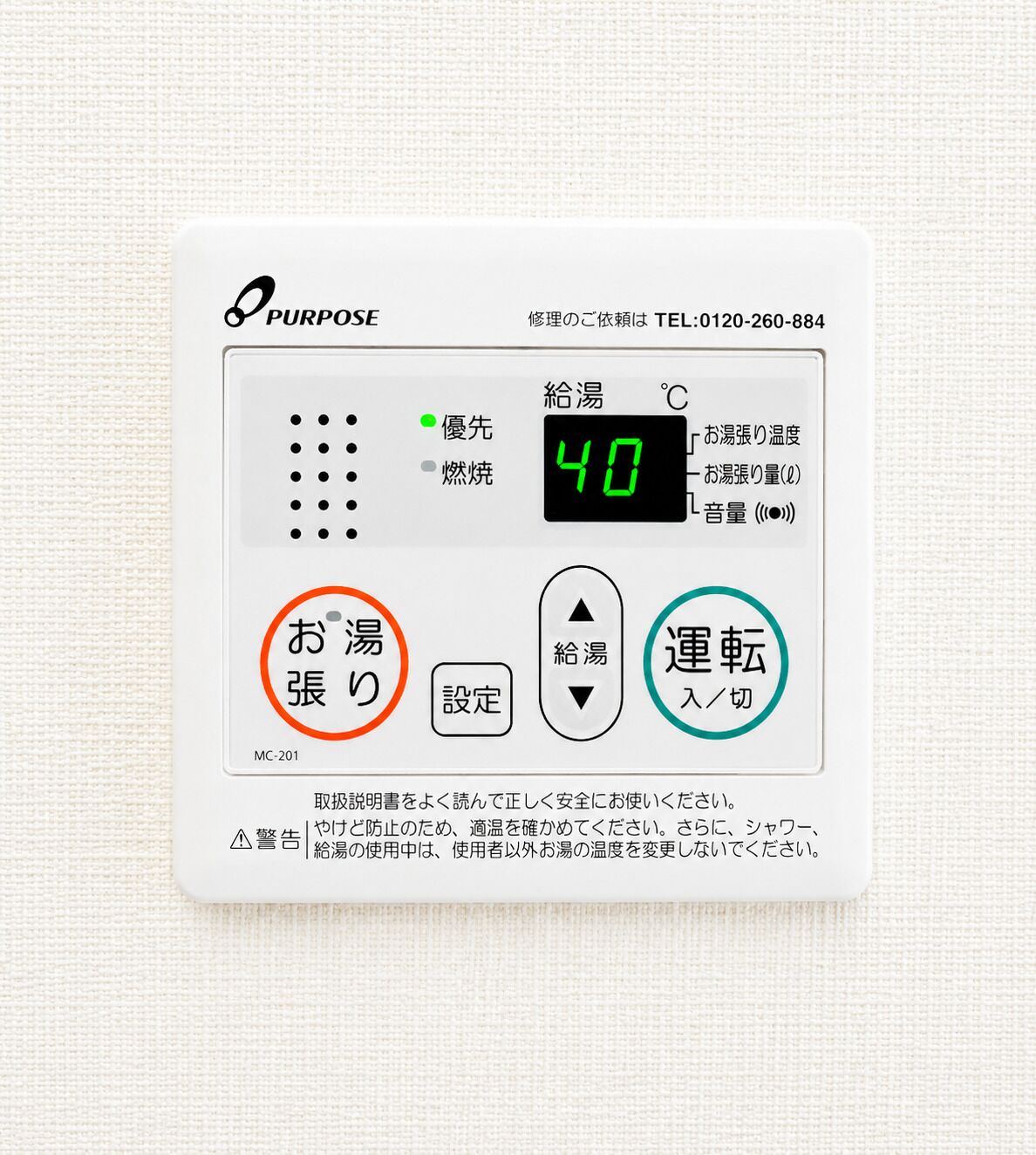 En digital termostat med display der viser 40 grader Celsius, knapper til temperaturjustering og et telefonnummer.