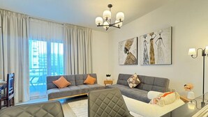 TV, books - Al Reef Retreat: Your 1BR w/ Sofa Beds, Pool & Gym (Abu Dhabi)