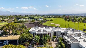 A resort with multiple buildings, a golf course, and a view of distant mountains. - Luxury Vacation Retreat at Mauna Lani Point (Kamuela)