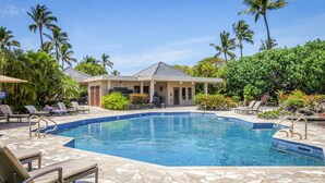 A swimming pool with lounge chairs and a building in the background.