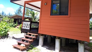 Een houten chalet met een veranda, een raam en een klein terras.