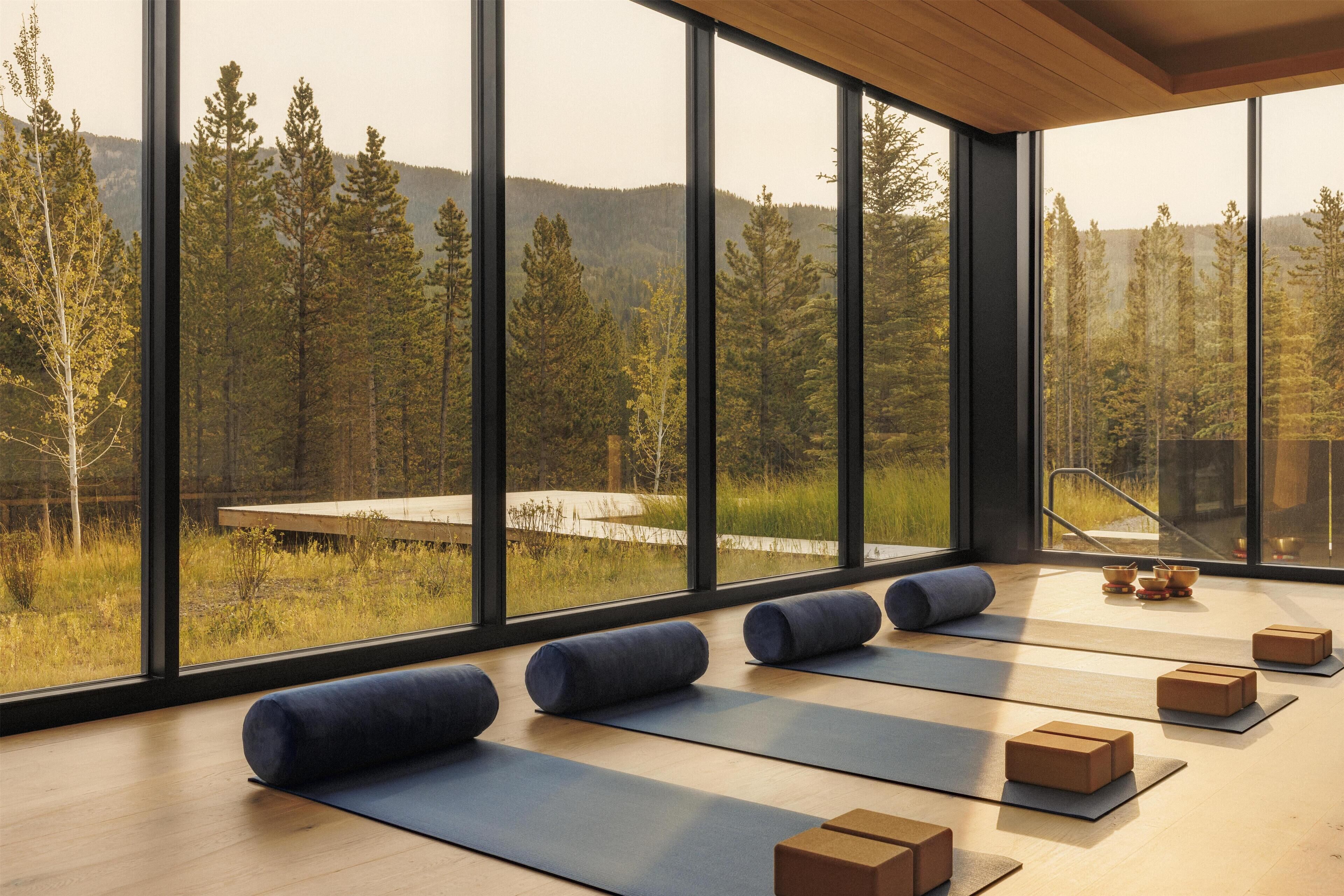 Un estudio de yoga con ventanas amplias, esterillas y bloques.