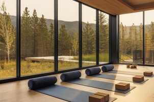 Un estudio de yoga con ventanas amplias, esterillas y bloques.