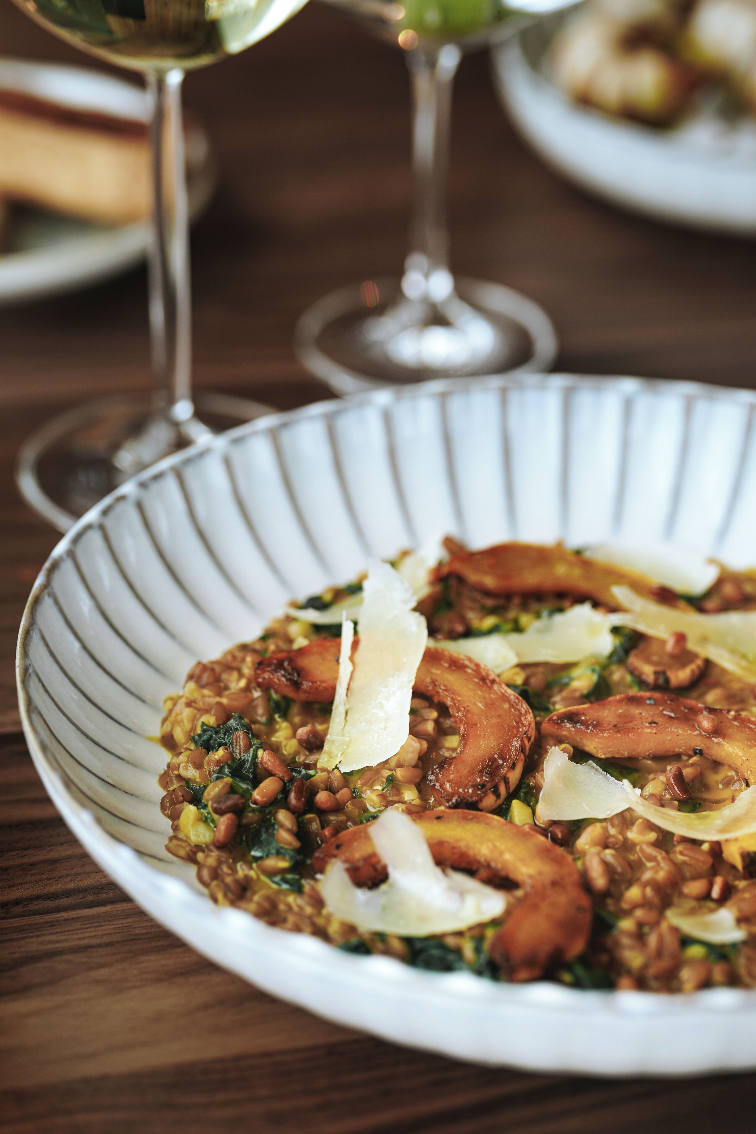 A bowl of risotto with mushrooms and parmesan on a plate.