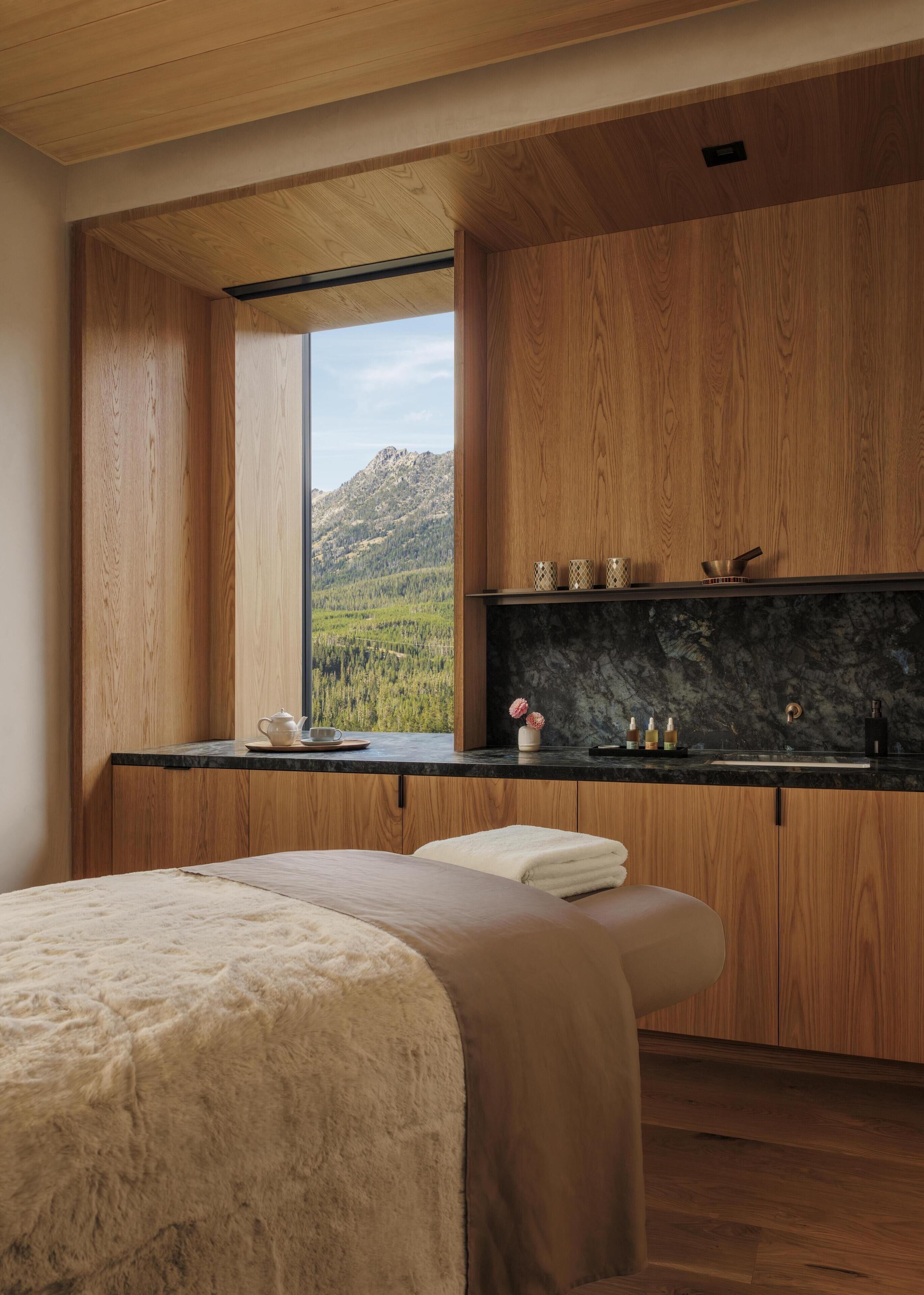 Une cuisine moderne avec des meubles en bois, un pare-feu en marbre et une vue sur un paysage montagneux.