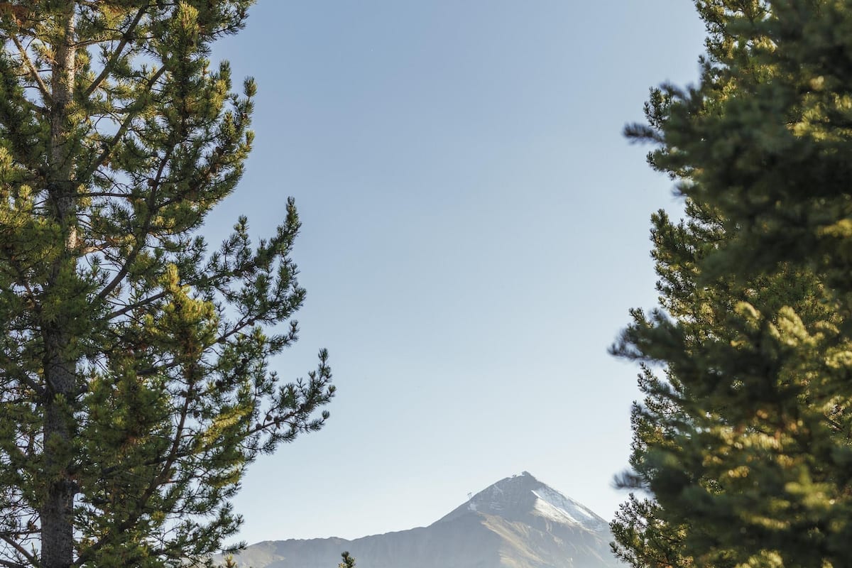 A modern outdoor seating area with a view of a mountain.