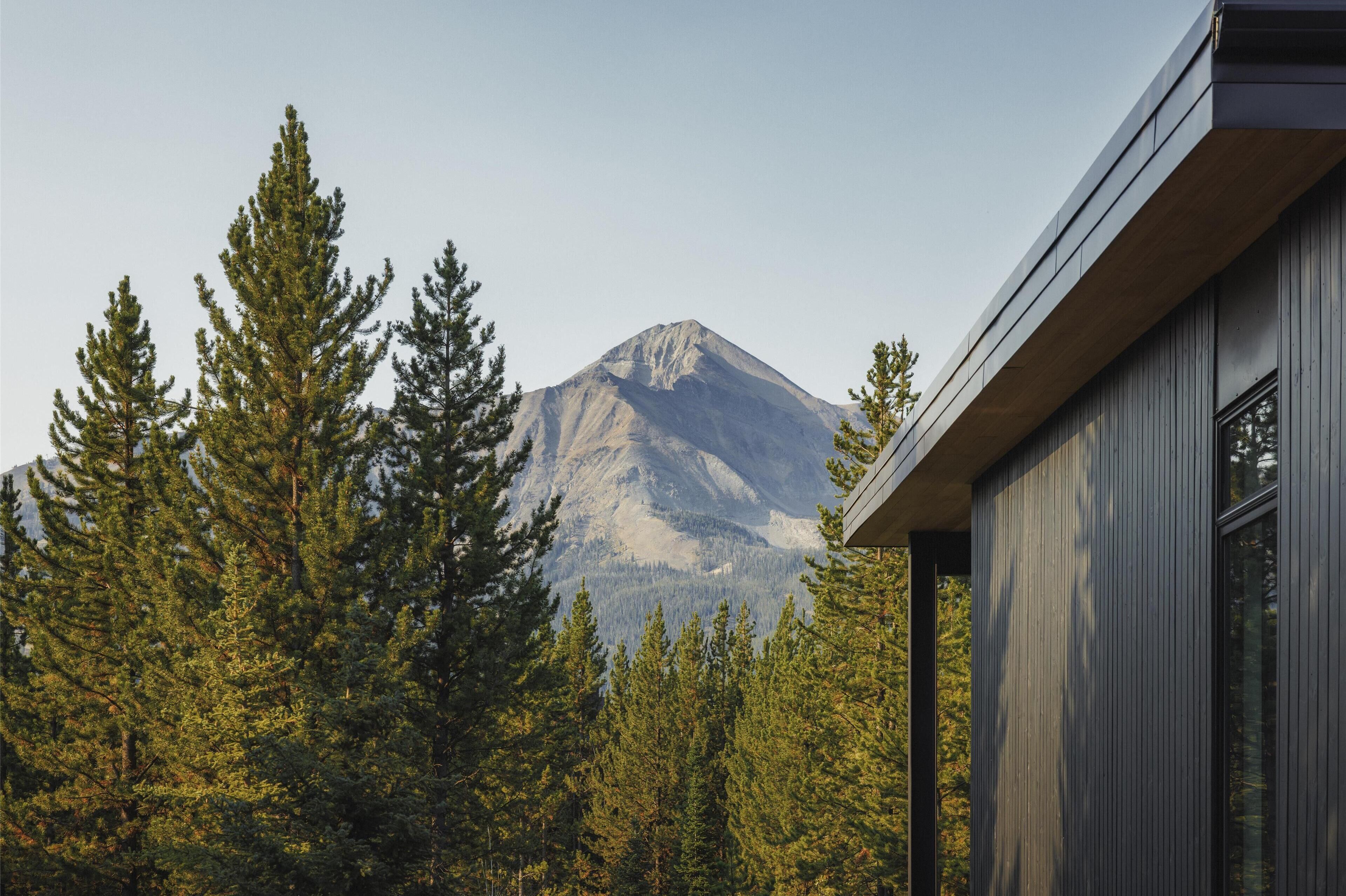 A mountain with a modern building in the foreground.