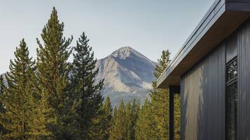 A mountain with a modern building in the foreground.