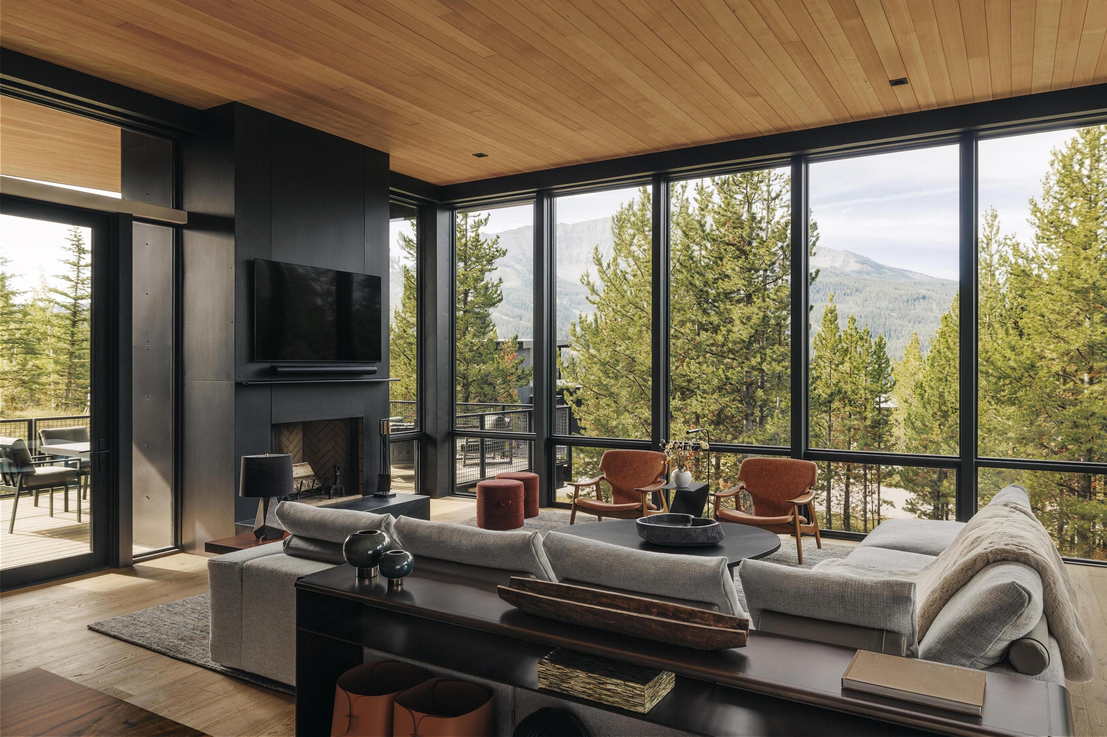 A modern living room with a large window, a fireplace, and a sofa.