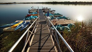 A wooden pier leading to a calm lake with kayaks and canoes docked on the right. - Charming villa with WiFi, AC, fitness room in fabulous Orlando (Orlando)