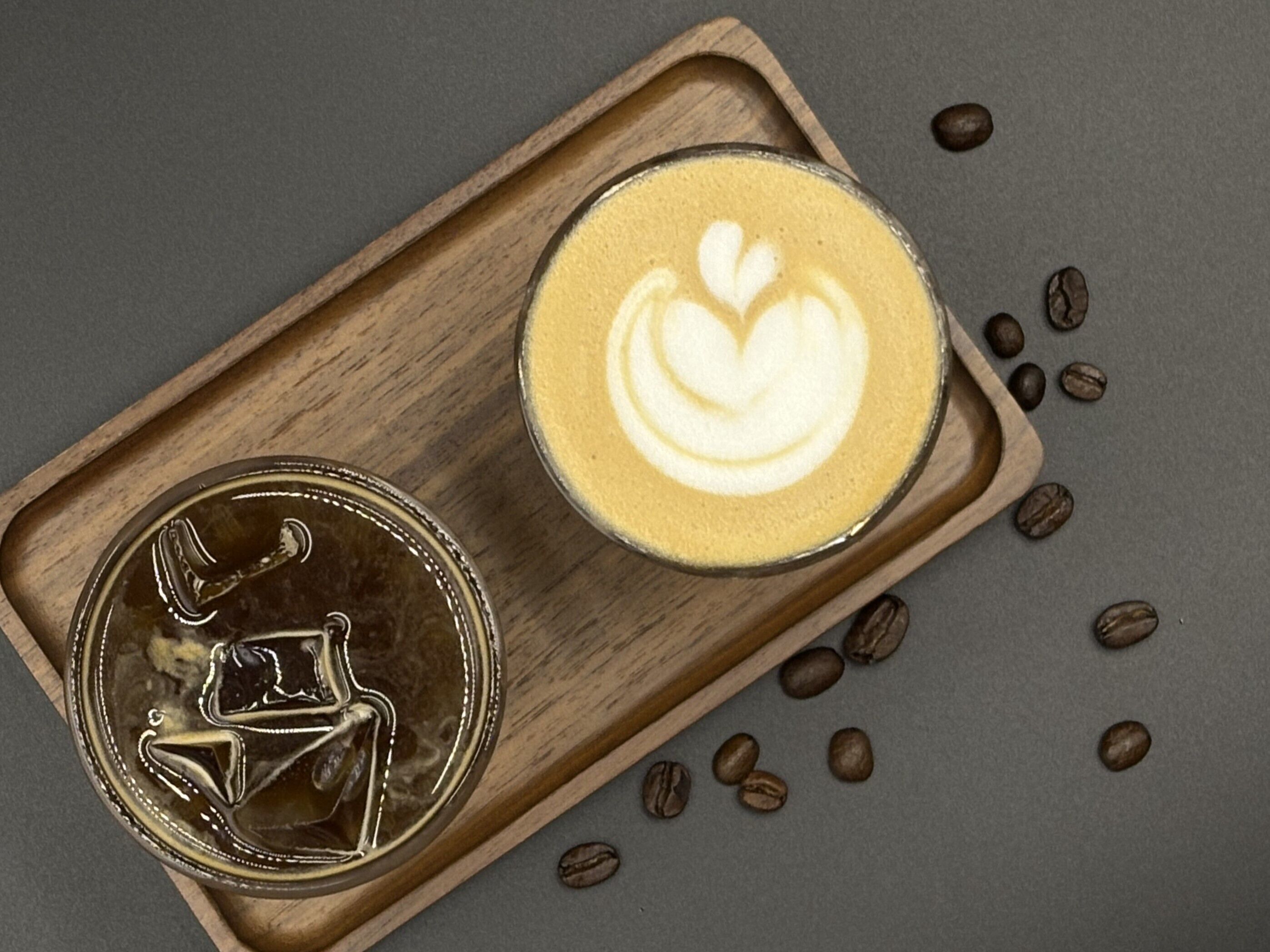 Uma bandeja com uma xícara de café e uma moeda sobre superfície de madeira.
